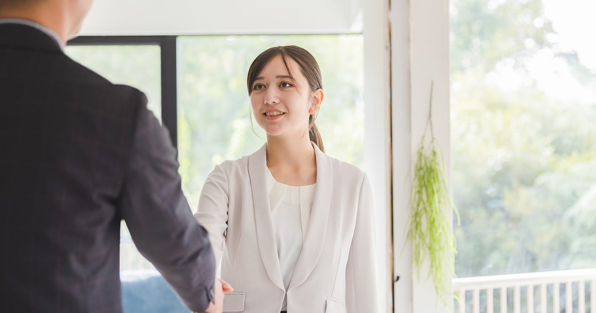 握手を交わすスーツ姿の男女