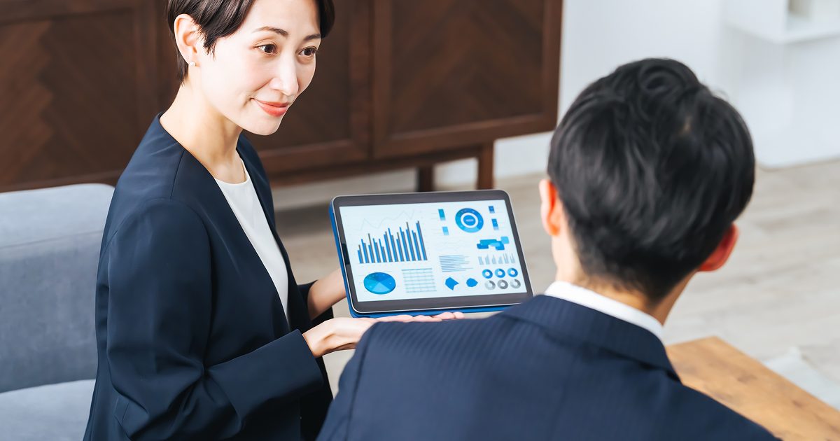タブレットに資料を映して商談相手に見せる女性