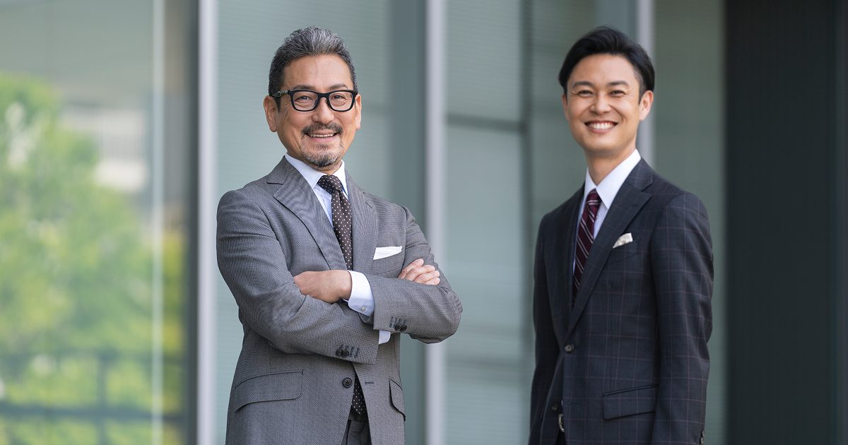 笑顔でこちらを向くスーツを着た二人の男性