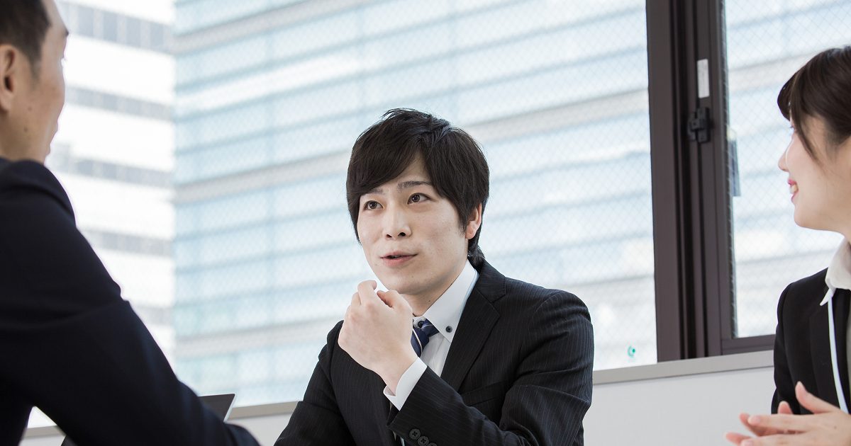 和やかな雰囲気で話し合うスーツ姿の男女