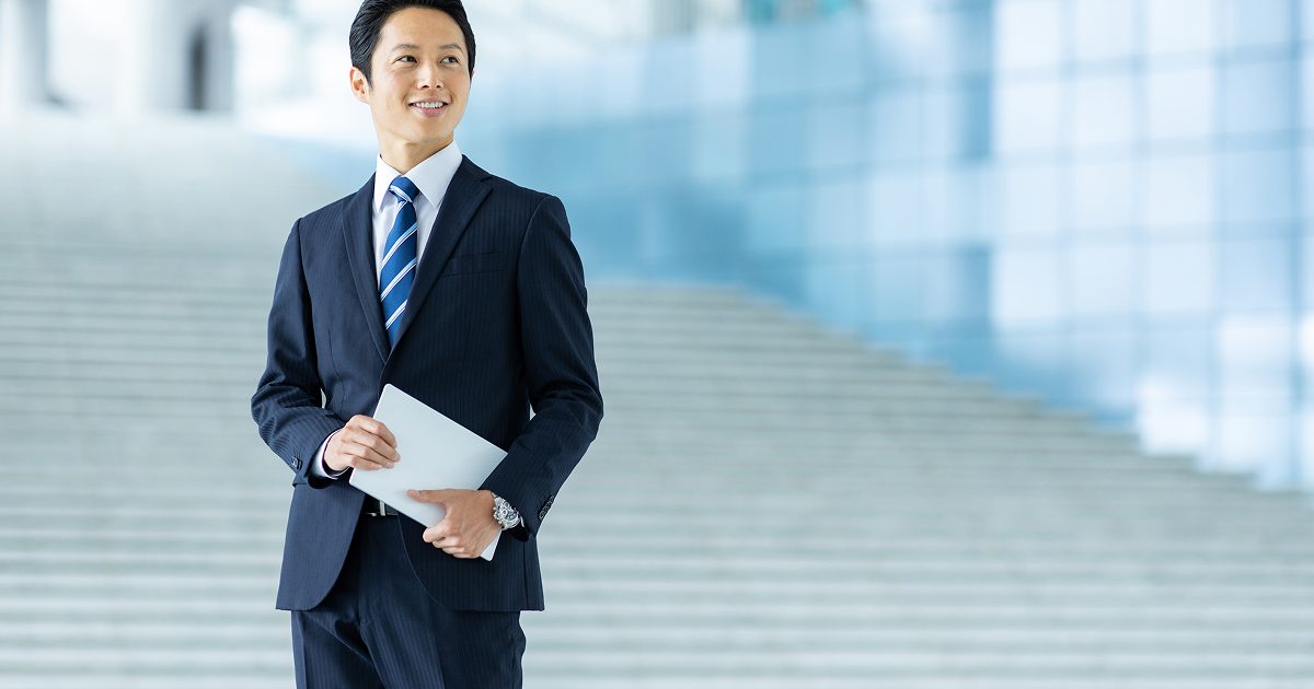 階段の前に立つスーツ姿の男性