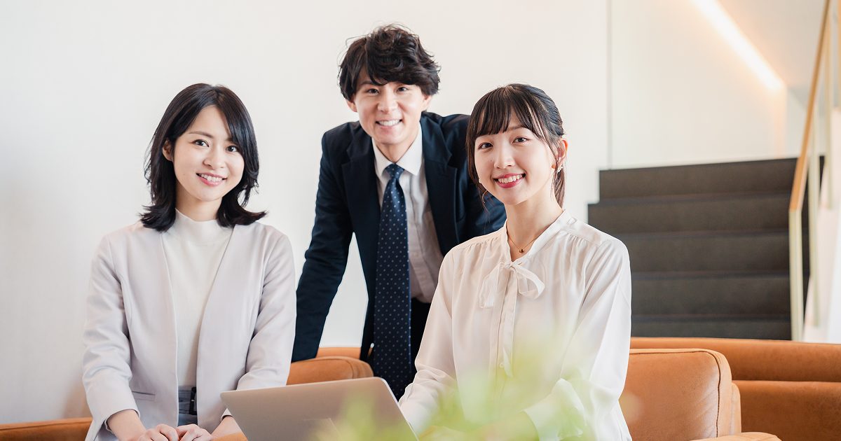 オフィスでほほ笑む3人の男女