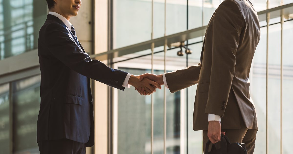 スーツを着た男性が握手をする様子