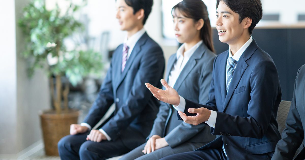 集団面接で話すスーツ姿の男性