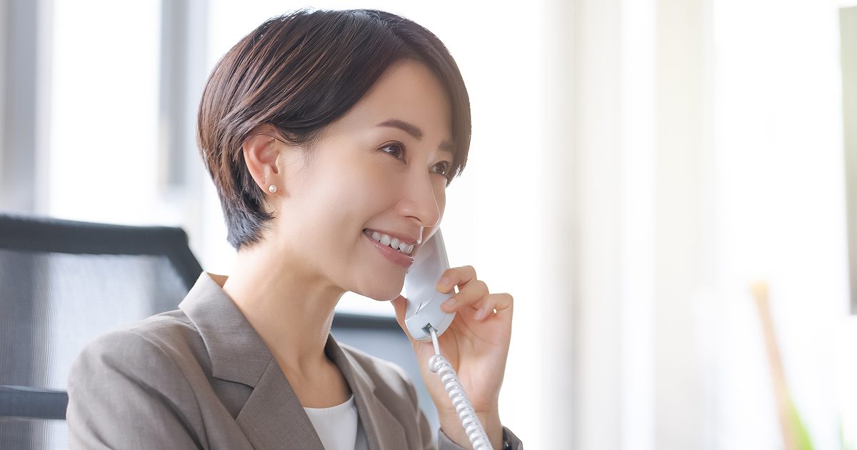 笑顔で電話に出る女性