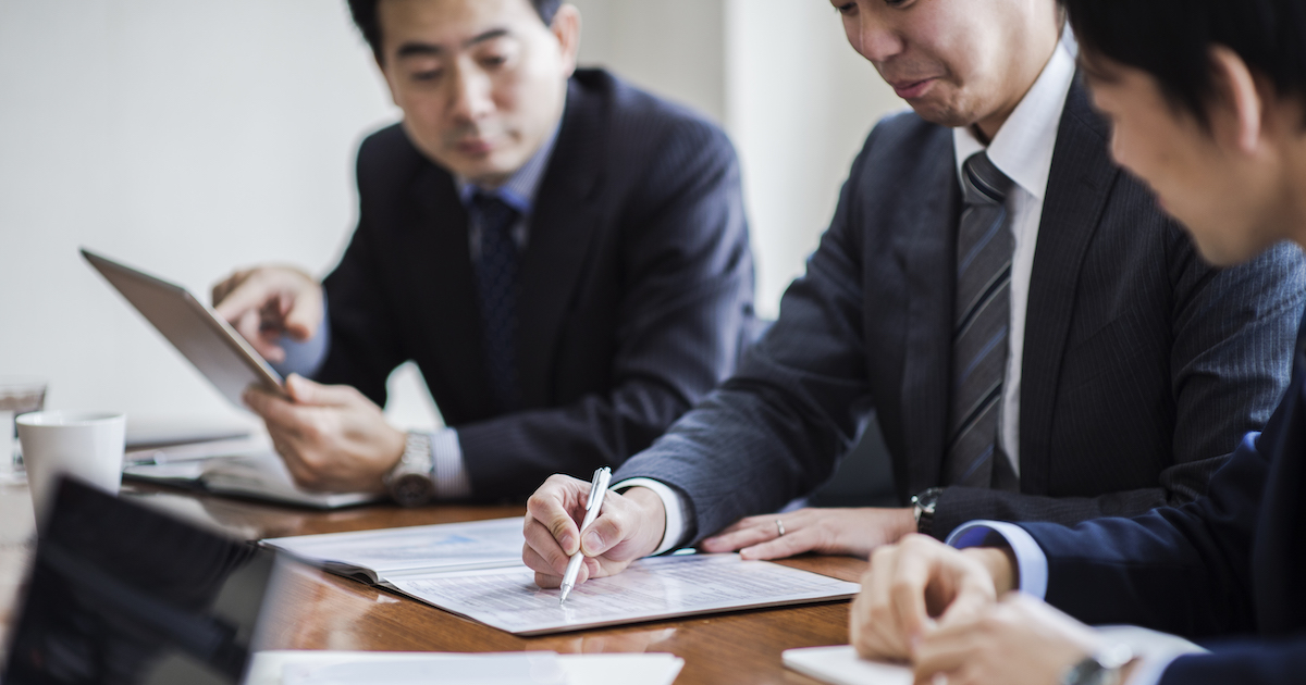 会議中に書類を読み込む男性