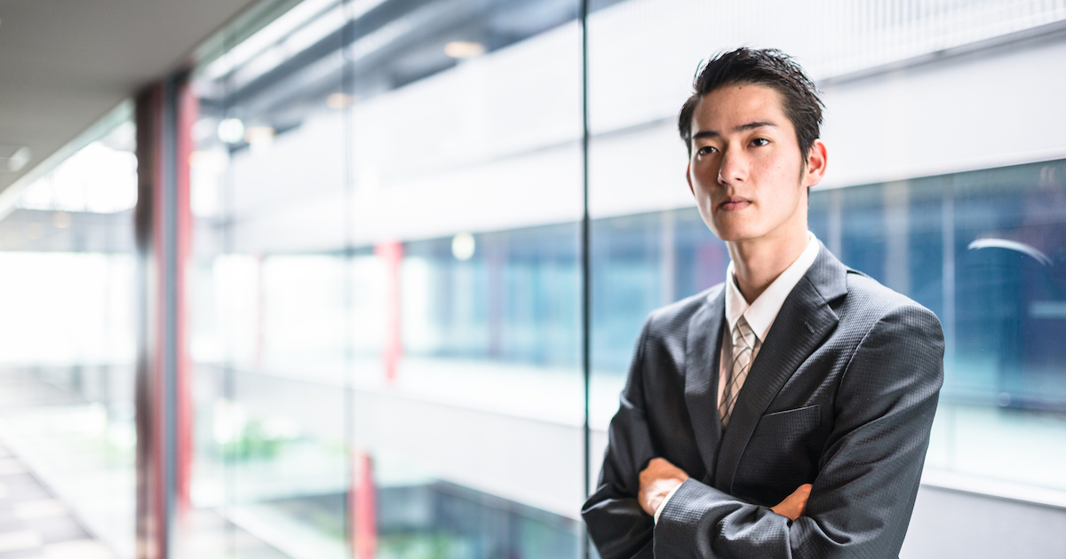 腕組みをして立つ男性