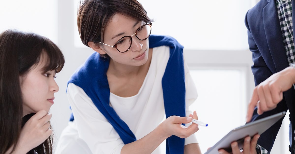 タブレットを見ながら話し合う男女