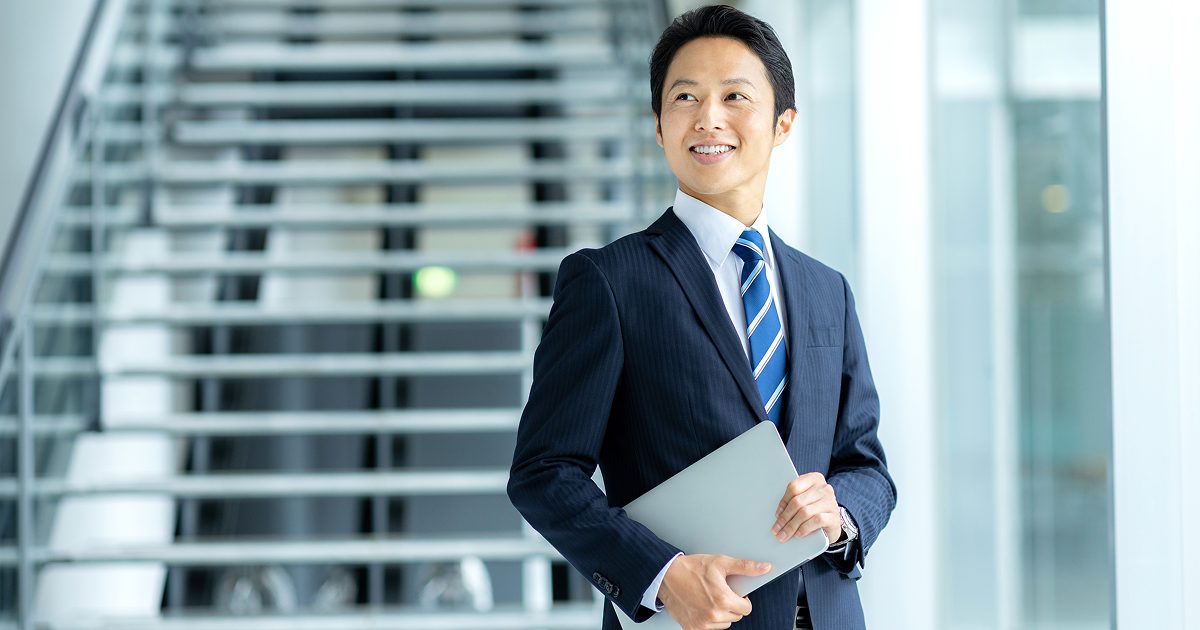 ノートパソコンを持っている笑顔の男性