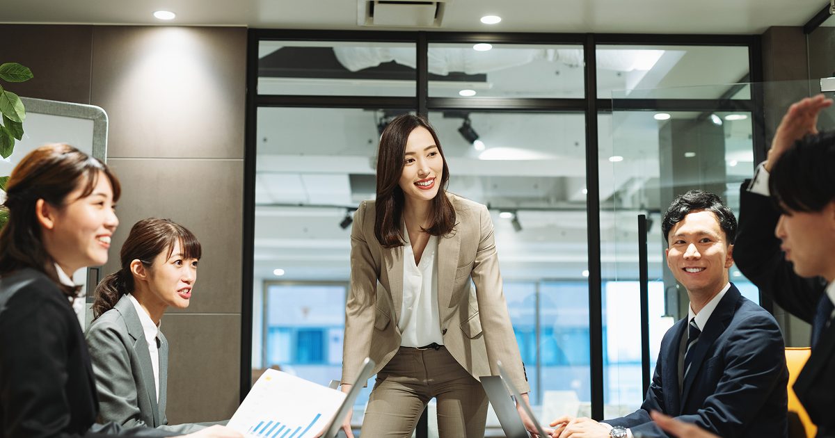 会議室で話し合う5人の男女