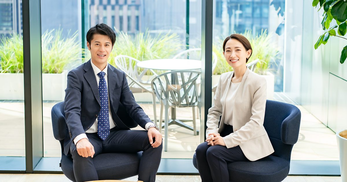 ソファに座る二人のビジネスパーソン