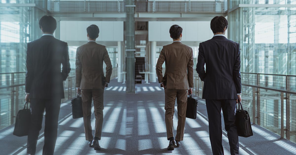 オフィスビルの廊下を歩く男性の後ろ姿
