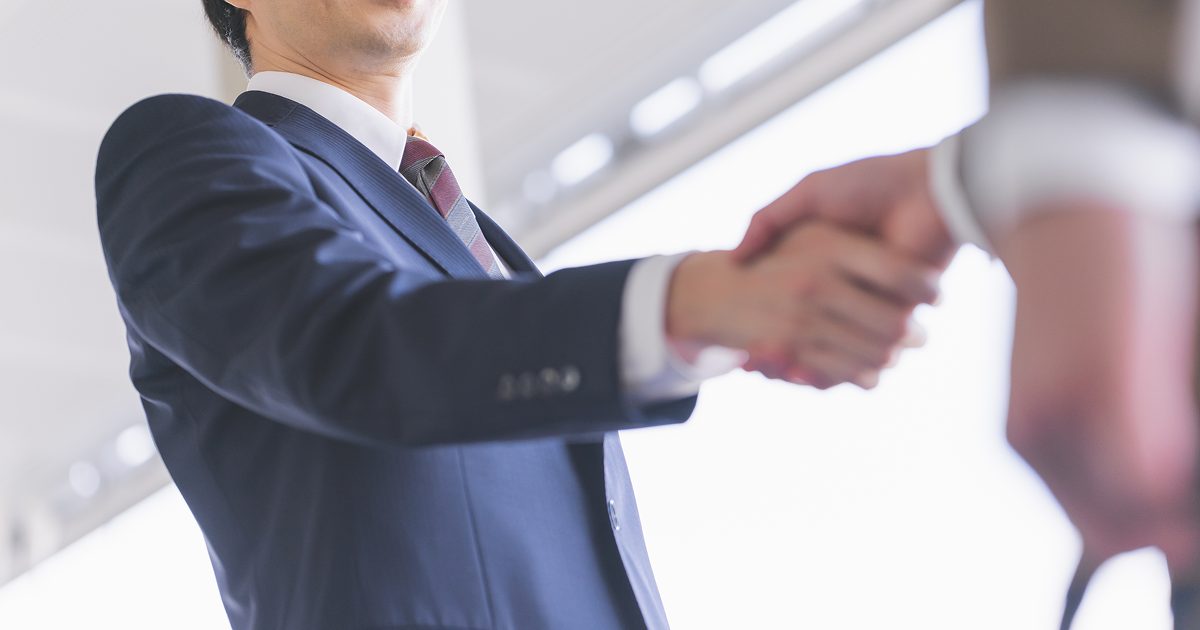スーツを着た男性が握手をする様子