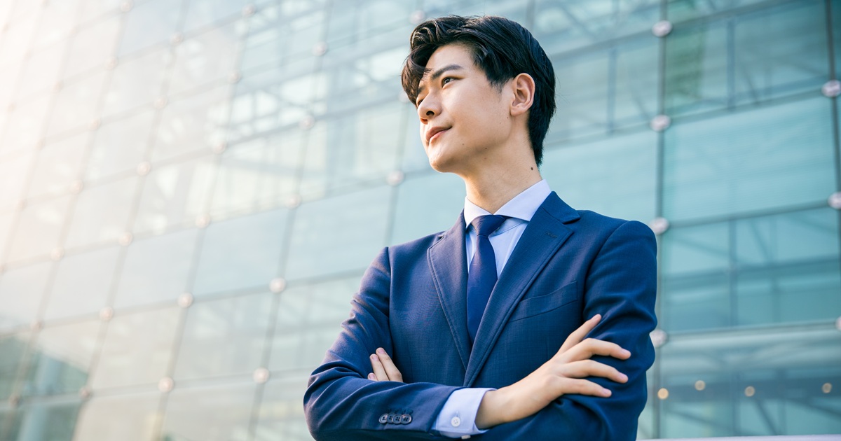 腕を組んだスーツ姿の男性